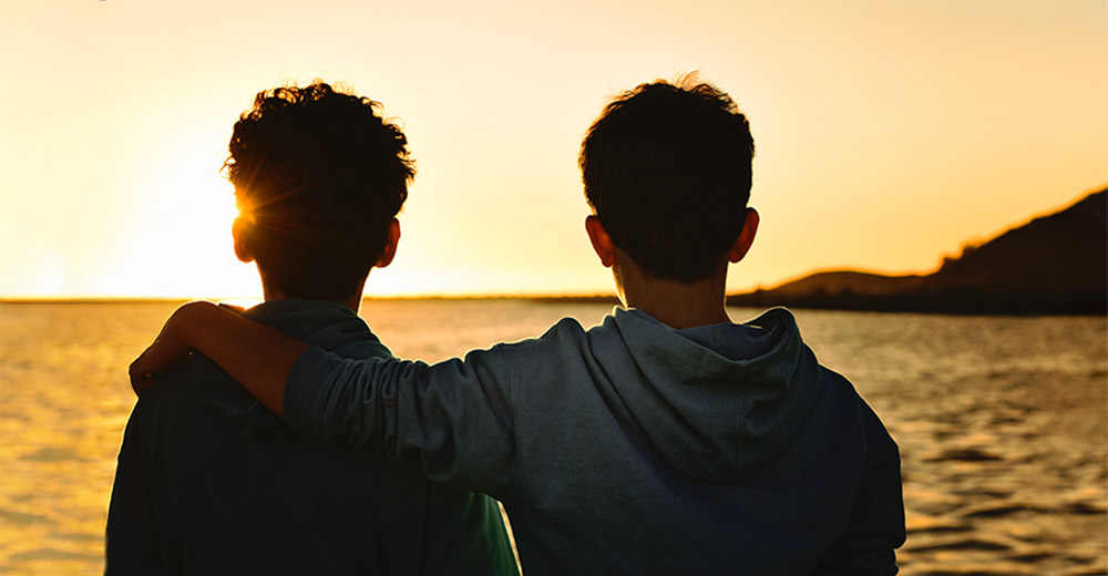 Two friends looking at sunrise