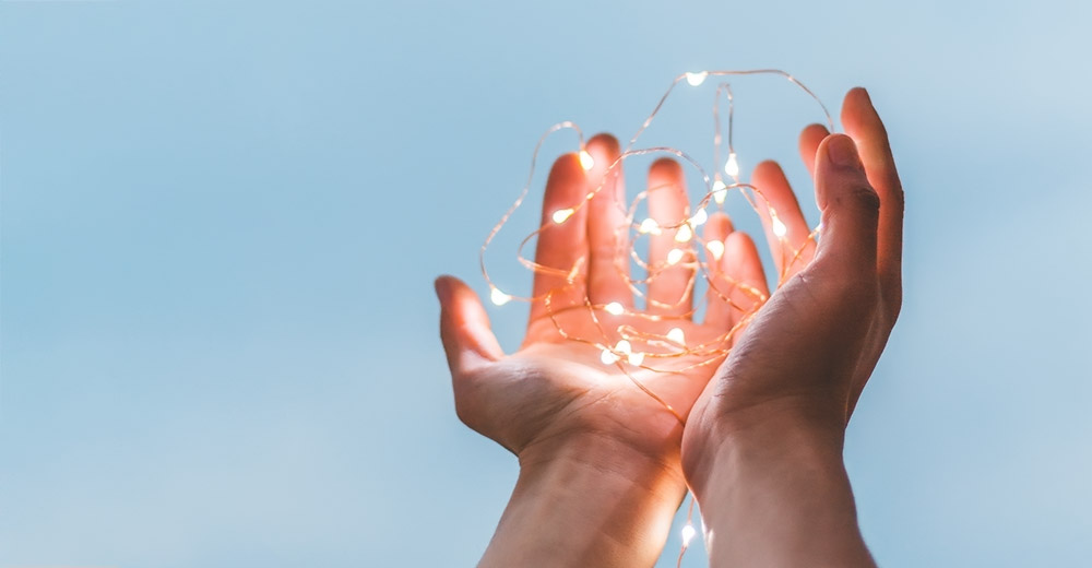 Hands holding string lights